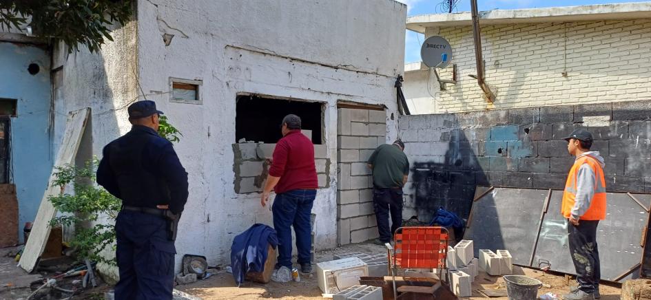 peronal de la intendencia y Policías tapiando la vivienda