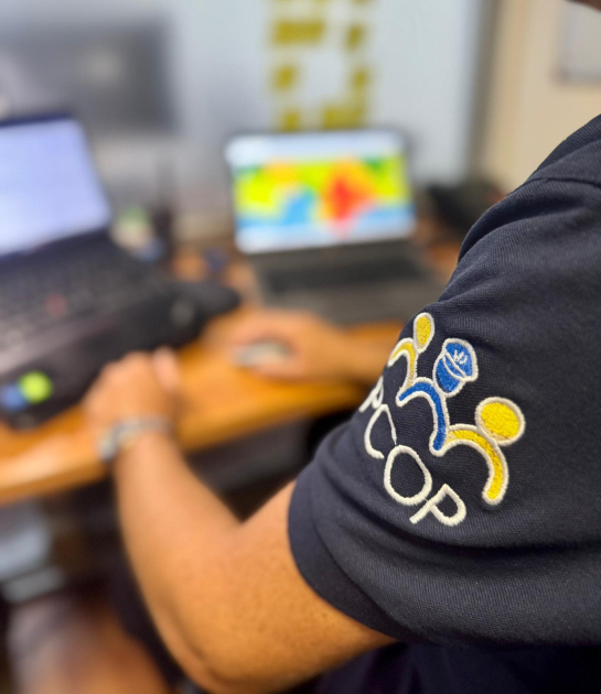 Proyectos Pcop Funcionario trabajando en una computadora con el logo de Policía Comunitaria