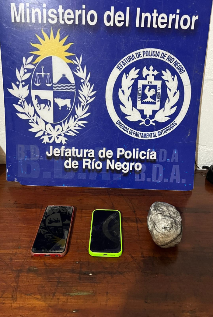 objetos incautados en procedimiento en una mesa dos celulares y un envoltorio
