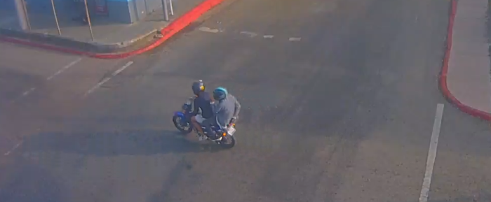 dos hombres cirulando en la calle sobre una moto