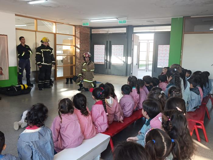 Grupo de niñas y niños en clase con Bomberos