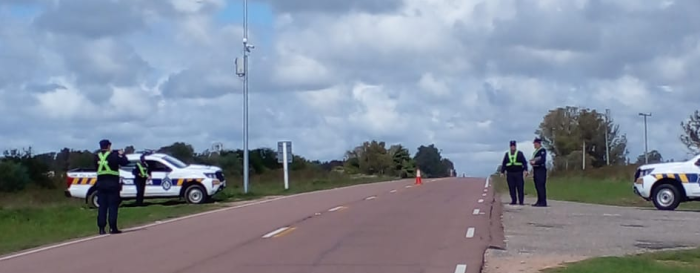 cuatro policías parados al costado de una ruta, realizando un operativo 