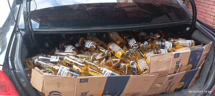 Botellas de coronas en valija de automóvil. 