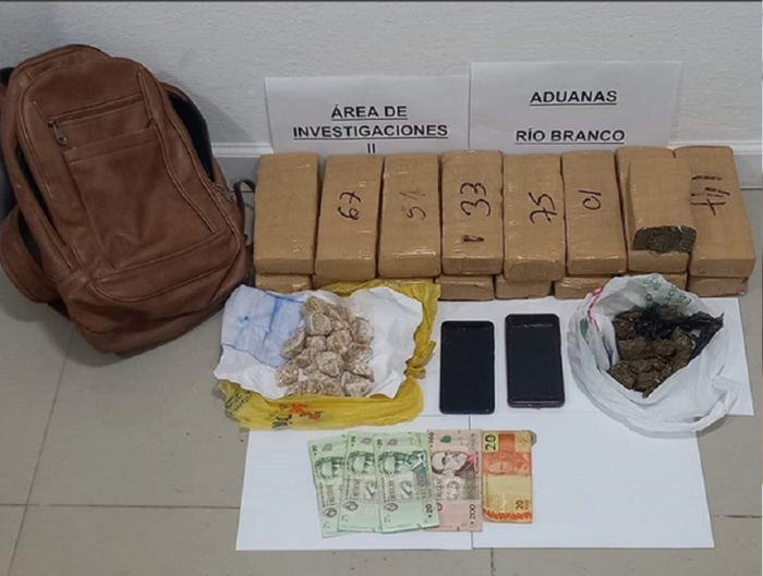 Objetos incautados a mujer que pretendía viajar en un ómnibus a Melo.. Mochila, dinero, marihuana prensada,pasta base de cocaína y dos teléfonos celulares.