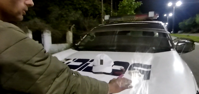 Detenido con manos sobre móvil policial 