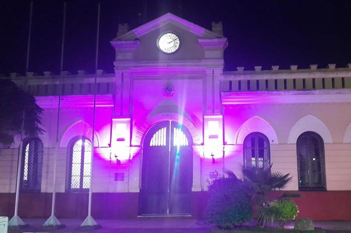 Edificio de Jefatura de Policía de Artigas iluminado de color violeta.