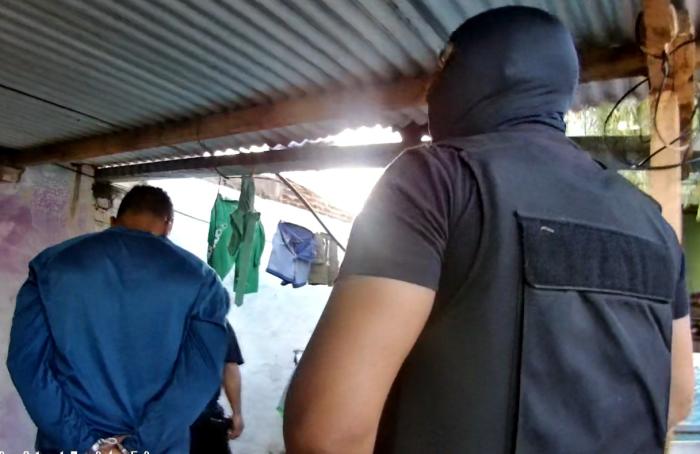 Foto de una persona detenida y un efectivo policial Foto de una persona detenida y un efectivo policial