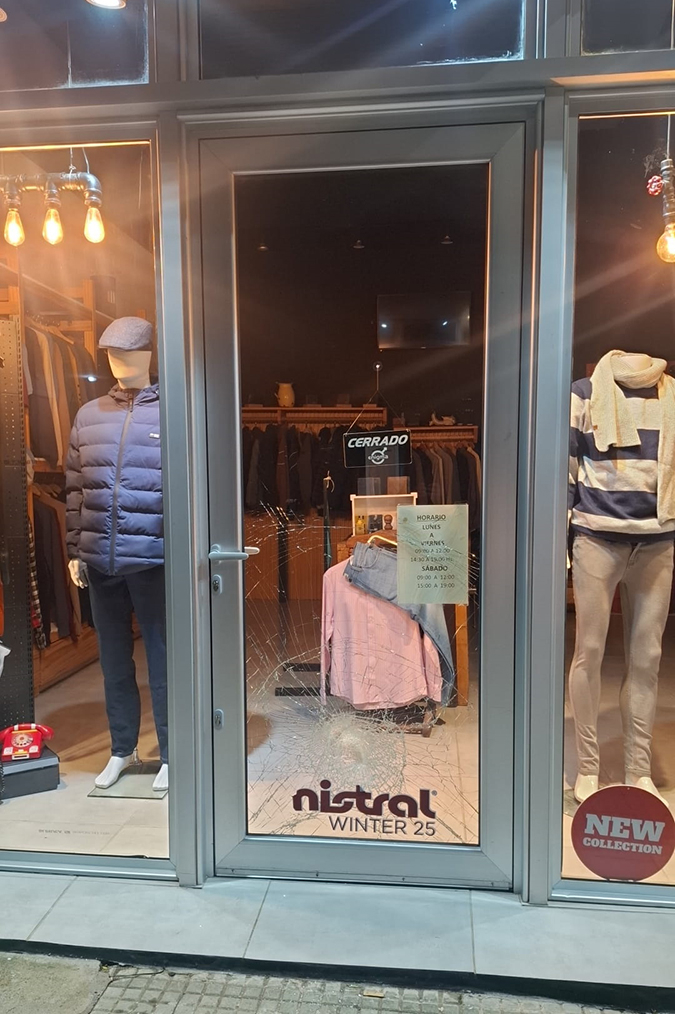 Frente de tienda de ropa con puerta de vidrio rota. Frente de tienda de ropa con puerta de vidrio rota.