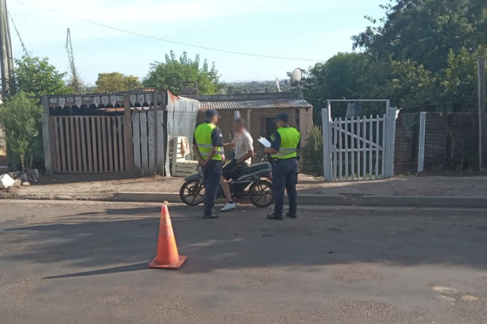 Hombre en moto siendo inspeccionado por dos policías Hombre en moto siendo inspeccionado por dos policías