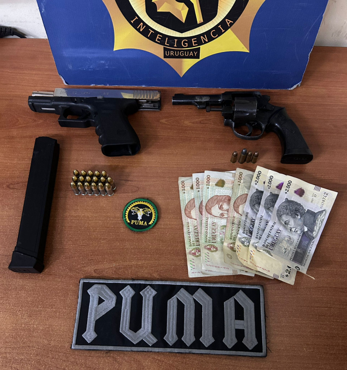 Objetos incautados por equipo policial Incautaciones sobre la mesa: dos armas, una pistola y un revolver, un cargador y dinero en efectivo.