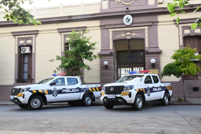 Móvil policial con fachada de la Jefatura al fondo