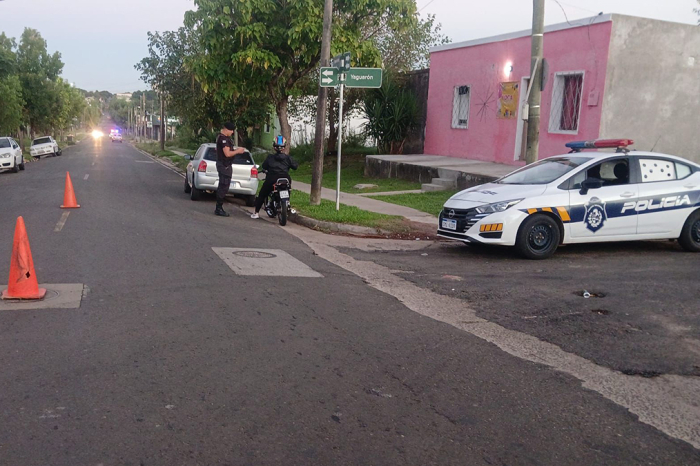 Policía en control policial a una motocicleta con una ocupante.