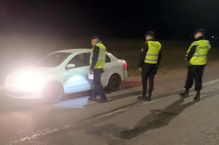 Policías controlando vehículo en Ruta. Tres Policías con un vehículo.
