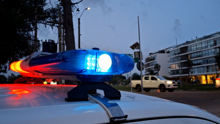 Barral de móvil policial encendido con luces azul y roja.