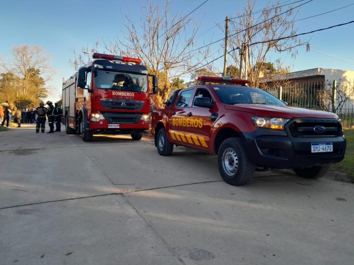 Bomberos en incendio de recidencial Camión y camioneta de Bomberos frente a incendio