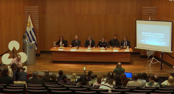 Autoridades sentadas en conferencia y publico presente