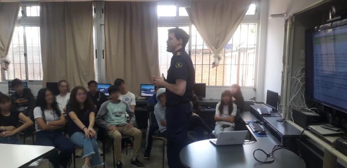 Funcionario policial dando charla a los alumnos.