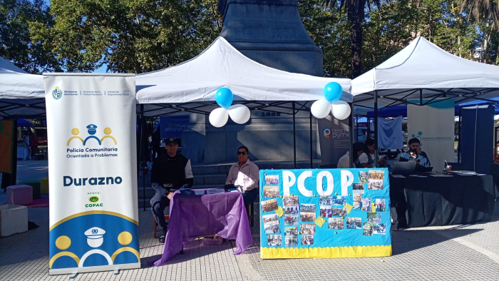 Personal de Policía Comunitaría en stand brindado información