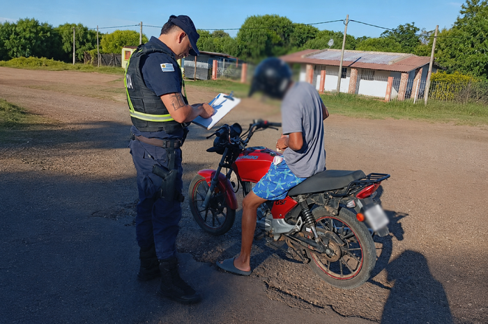 Un hombre en moto siendo inspeccionado por la policía Un hombre en moto siendo inspeccionado por la policía