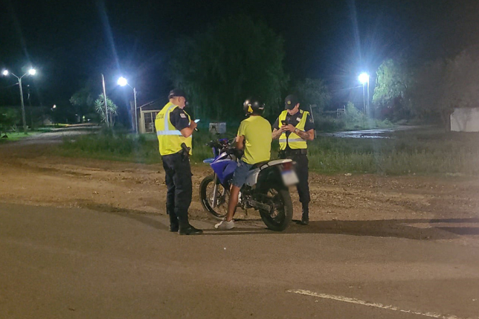 Un hombre en motocicleta siendo inspeccionado por la policía