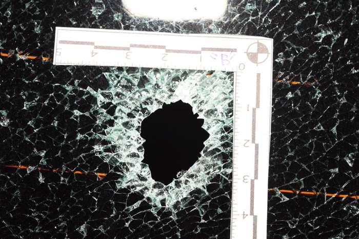 Vidrio de automóvil con orificio de proyectil.