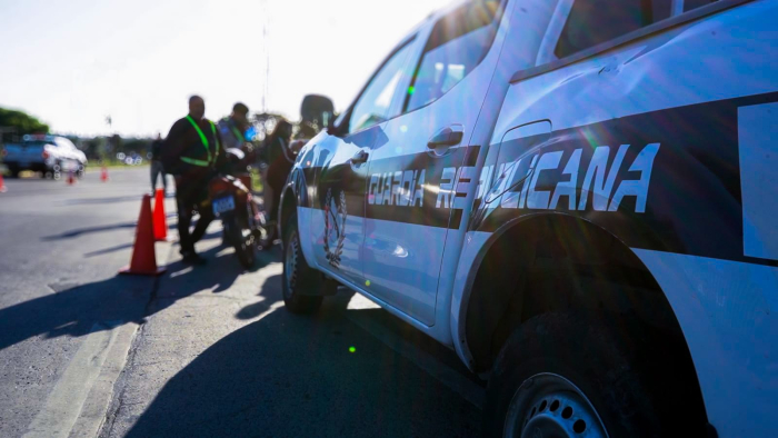 Móvil de la Guardia Republicana estacionado con personas al fondo