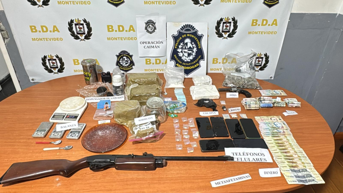 Sobre una mesa se muestra producto de la incautación, drogas, armas...