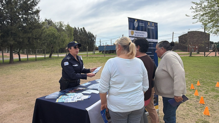 Policía con personas acercandose al stand 