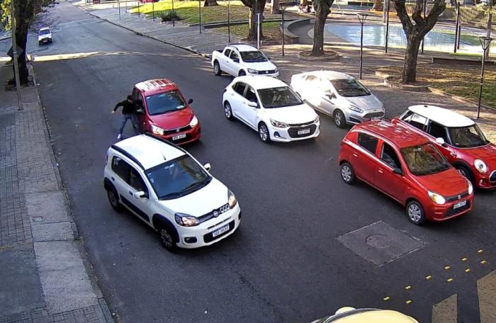 imagen del ladrón rompiendo el vidrio del auto