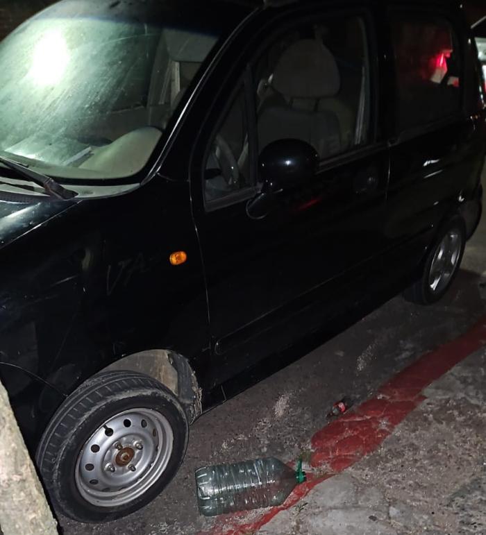 auto estacionado y un bidón de plástico vacío tirado en el piso