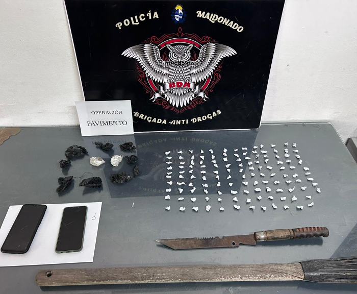 envoltorios con cocaina y armas incautadas, exhibidas sobre una mesa