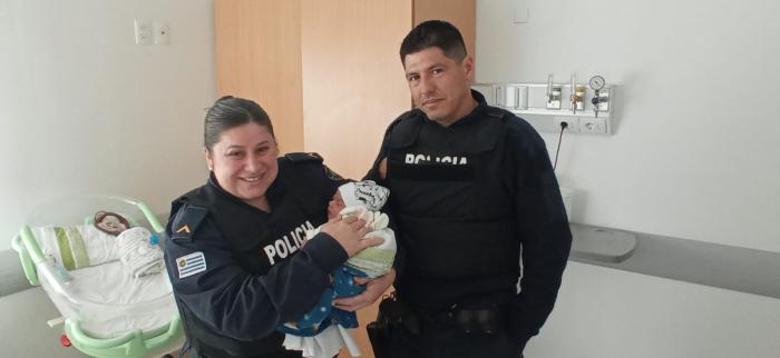 Policias junto al bebé que asisiteron 