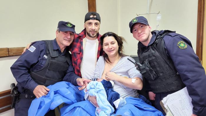 madre, junto a los bebés y policías que asistieron el parto
