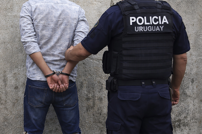 Hombre detenido y esposado por la policía. Imagen ilustrativa generada por Inteligencia Artificial