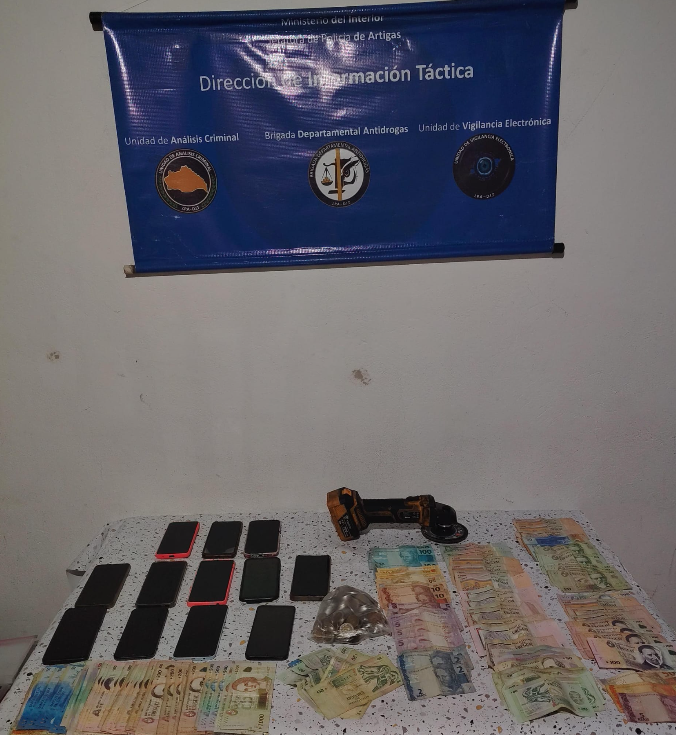Mesa con celulares, dinero en efectivo y otros objetos incautados