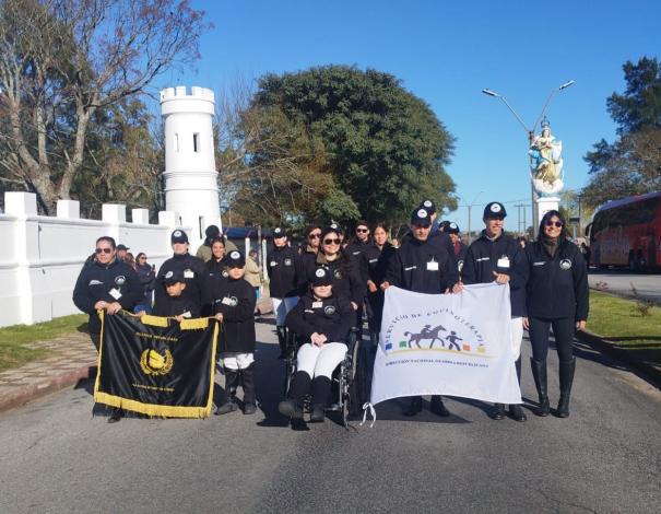 Equipo de deportistas y profesionales de equinoterapia de la DNGR, de pie posando juntos