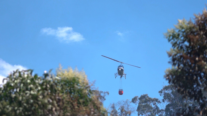 Helicóptero de Aviación con helibalde en foco de incendio