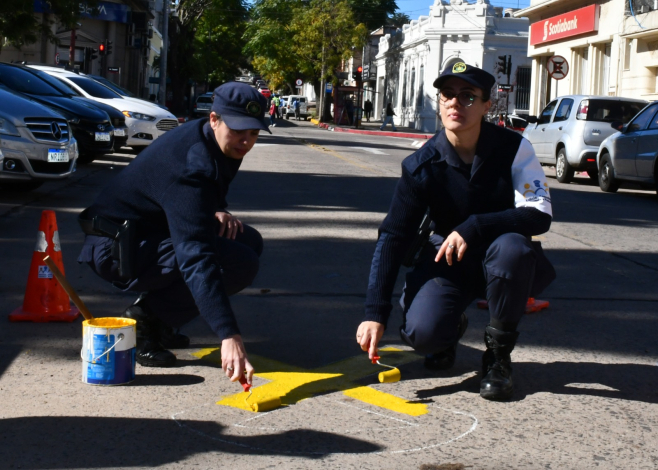 Policías pintando un lazo amarillo en el piso