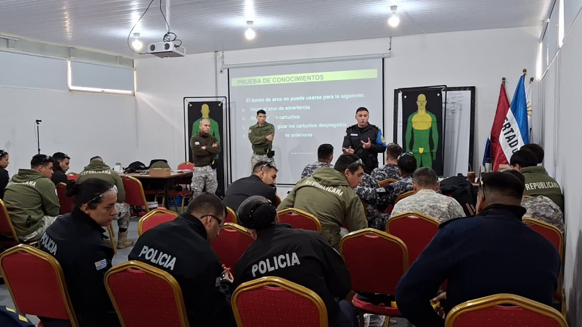 Personal de la DNGR, DIGOE y JPM en salón durante instrucción taser