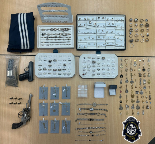 Armas, joyas, incautadas exhibidas sobre una mesa tras allanamientos