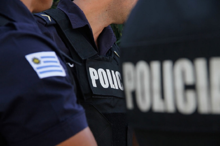 insigneas de policía y bandera de Uruguay en brazo y espalda de efectivos policiales