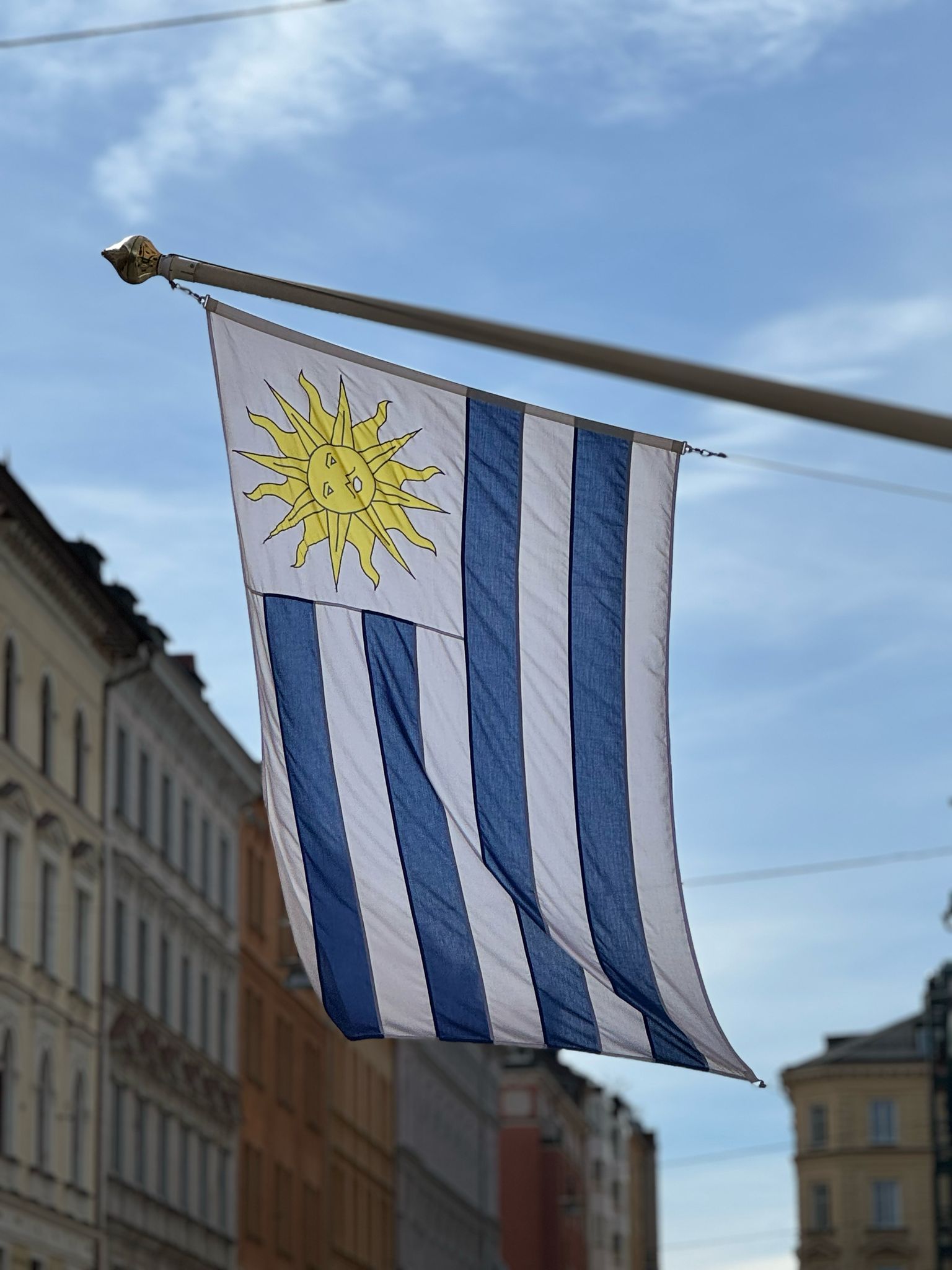 Bandera de Uruguay en la Embajada, con cielo celeste de fondo
