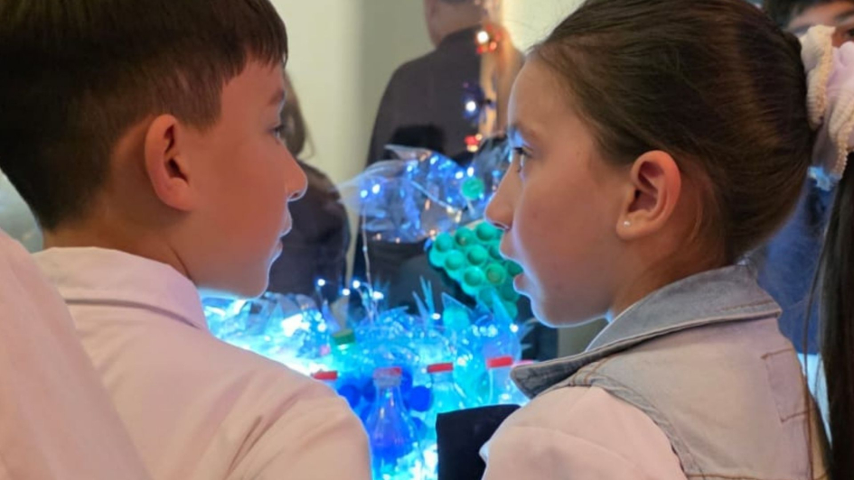 Niños mirando pieza que se encuentra en la exposición