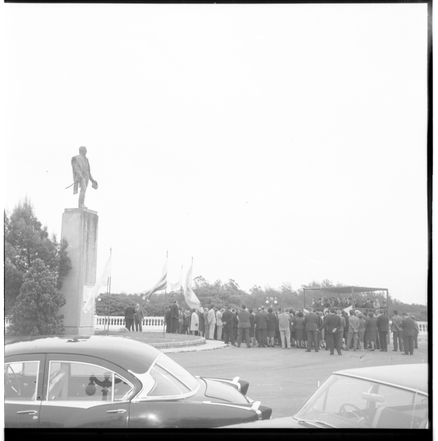 Foto del estrado al costado del monumento y del público asistente.