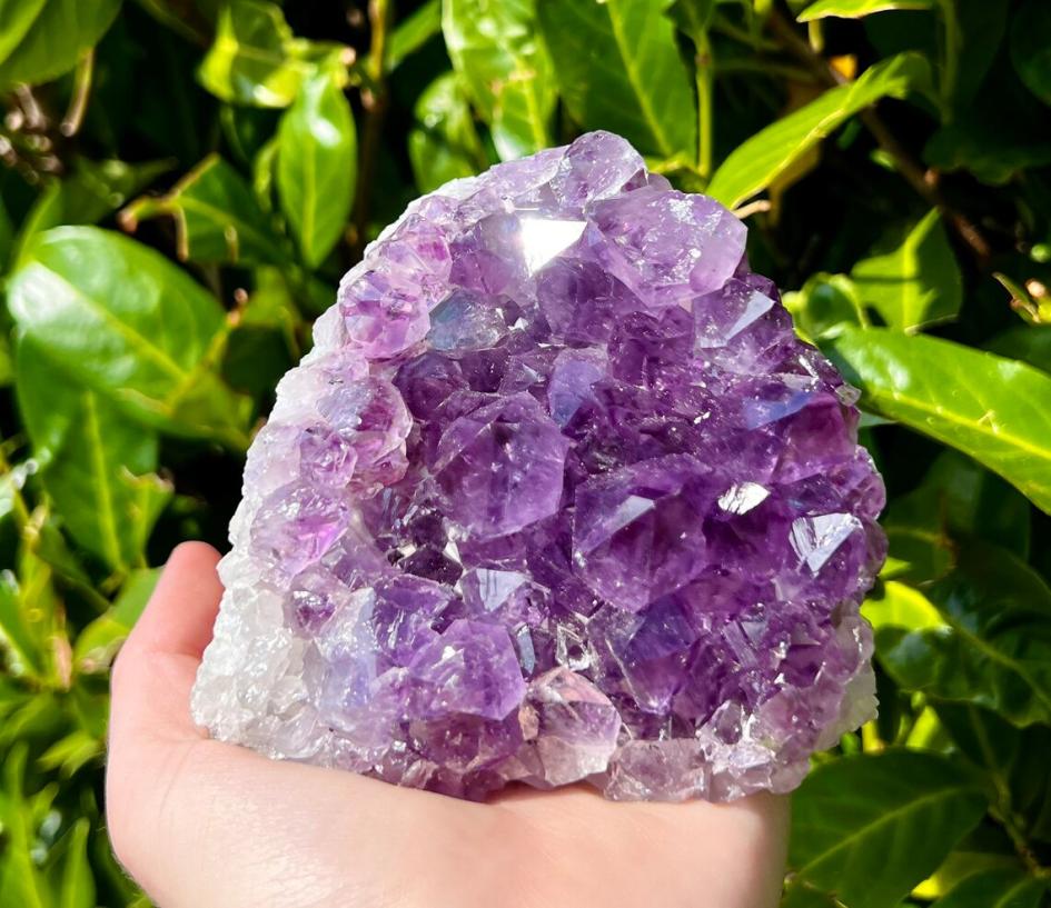 Amatista Piedra amatista en la palma de la mano de una persona