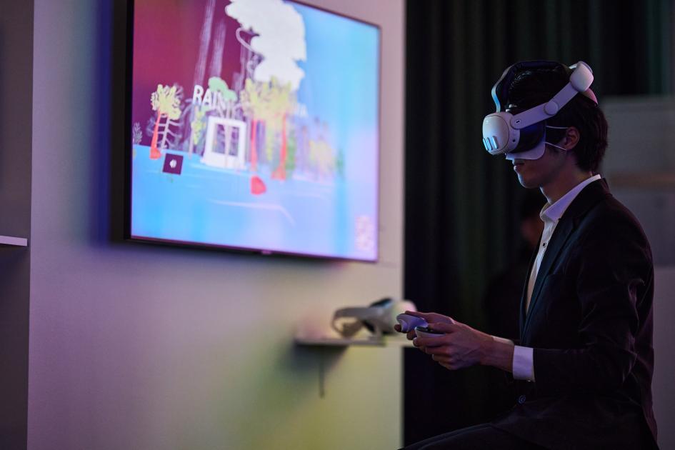 Moving Letters Visitante de la exposición apreciando una obra mediante el uso de lentes de realidad virtual.