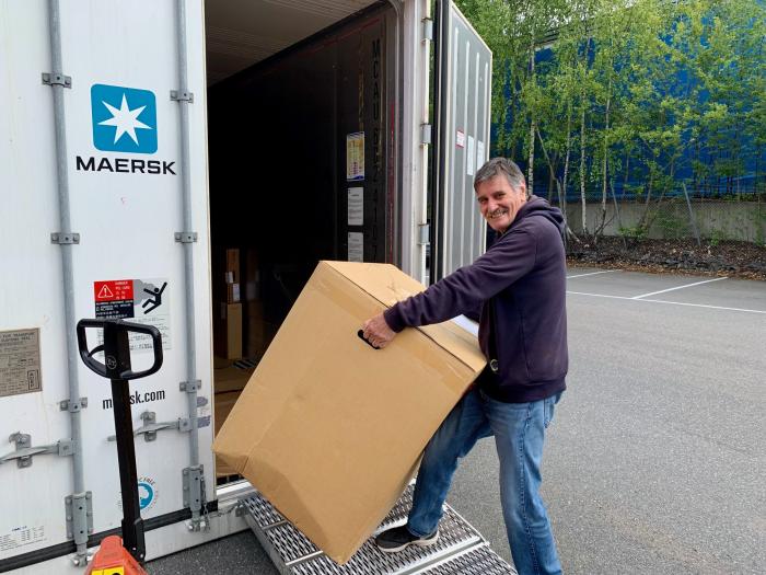 Compatriot Carlos Caballero loading a large box into the container