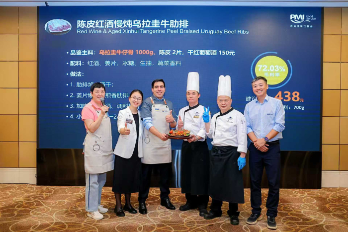 Organizadores y chefs muestran uno de los platos presentados Foto grupal frente al banner del evento, mostrando uno de los platos presentados