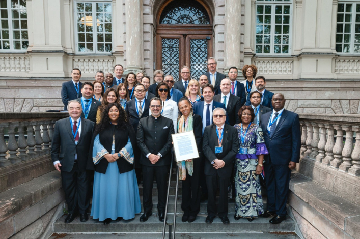 Participants of the event posing at the entrance of the International IDEA headquarters