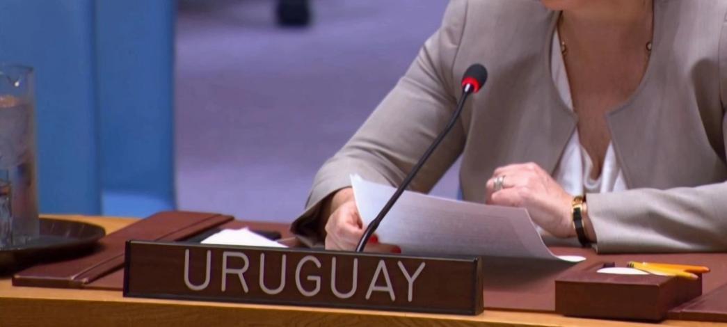 Imahen ilustrativa - Representante de Uruguay con un cartel "Uruguay" en una reunión internacional
